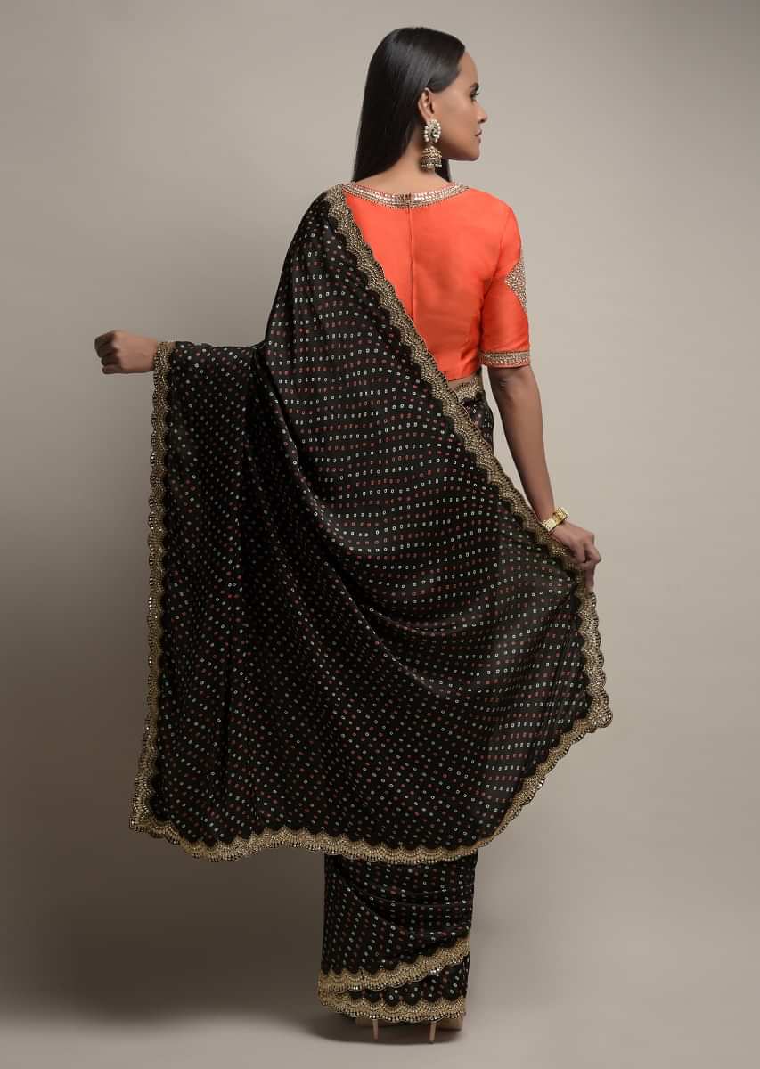 Black Saree In Satin Blend With Bandhani Print And Mirror Work Paired With Contrasting Coral Stitched Blouse
