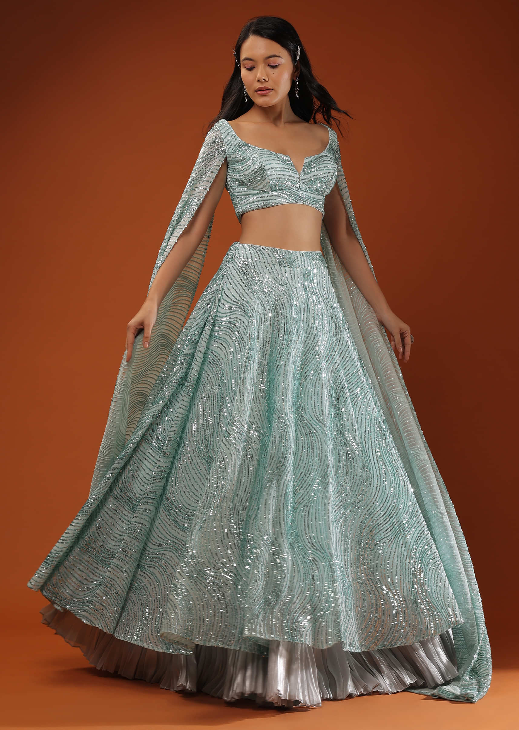 Blue Lehenga And A Crop Top In A Long Cape In Sequins Embroidery, Padding And A Back Hooks Closure.