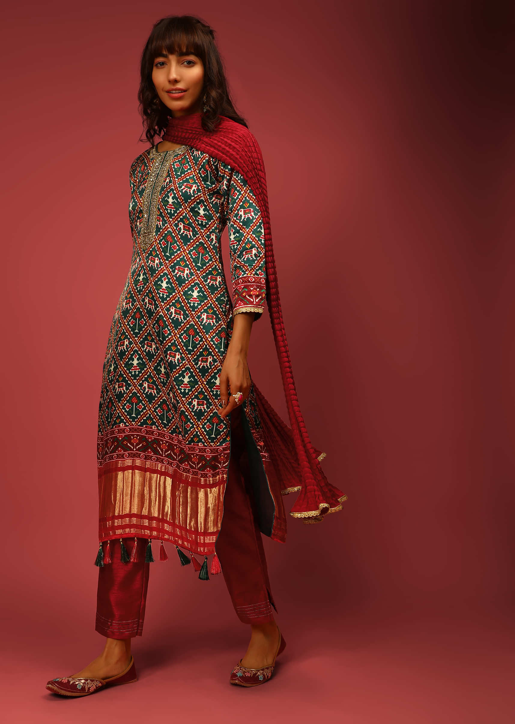 Bottle Green Straight Cut Suit In Satin Blend With Patola Print And Brocade Border Edged In Tassels  