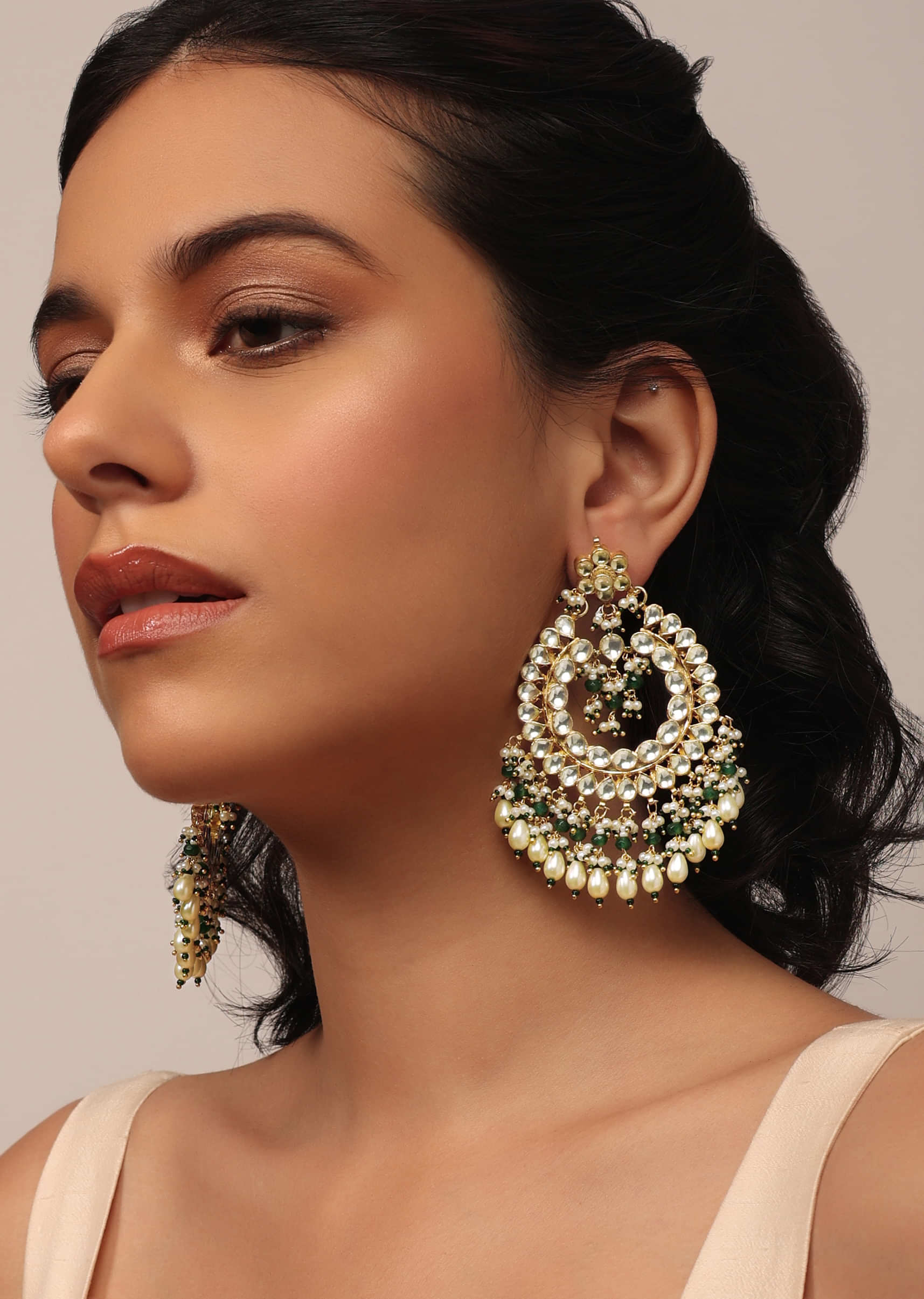 Gold Finish Kundan Earrings With Beads And Synthetic Emerald Stones