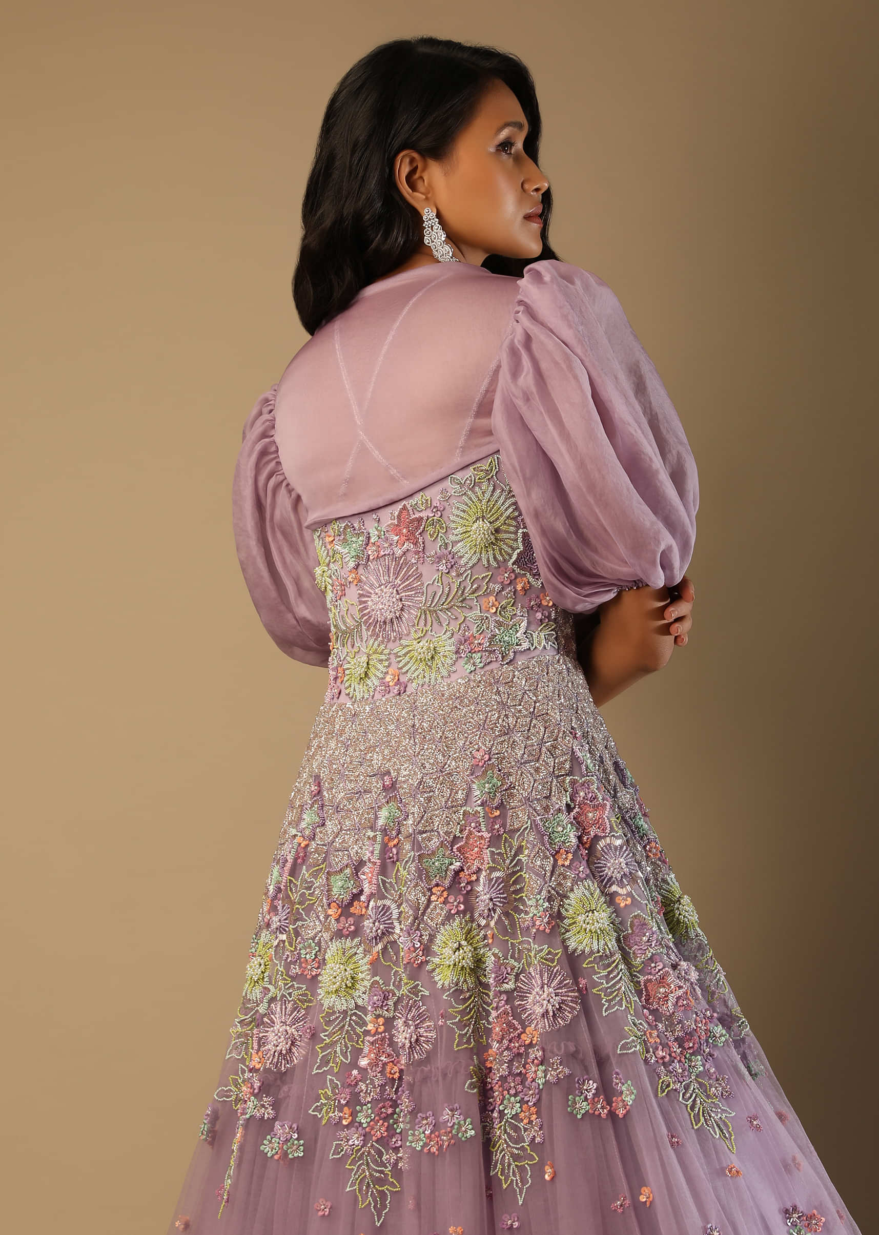 Lilac Mauve Gown In Net With Multi Colored Beads Embroidered Floral Motifs And A Puff Sleeves Organza Shrug  