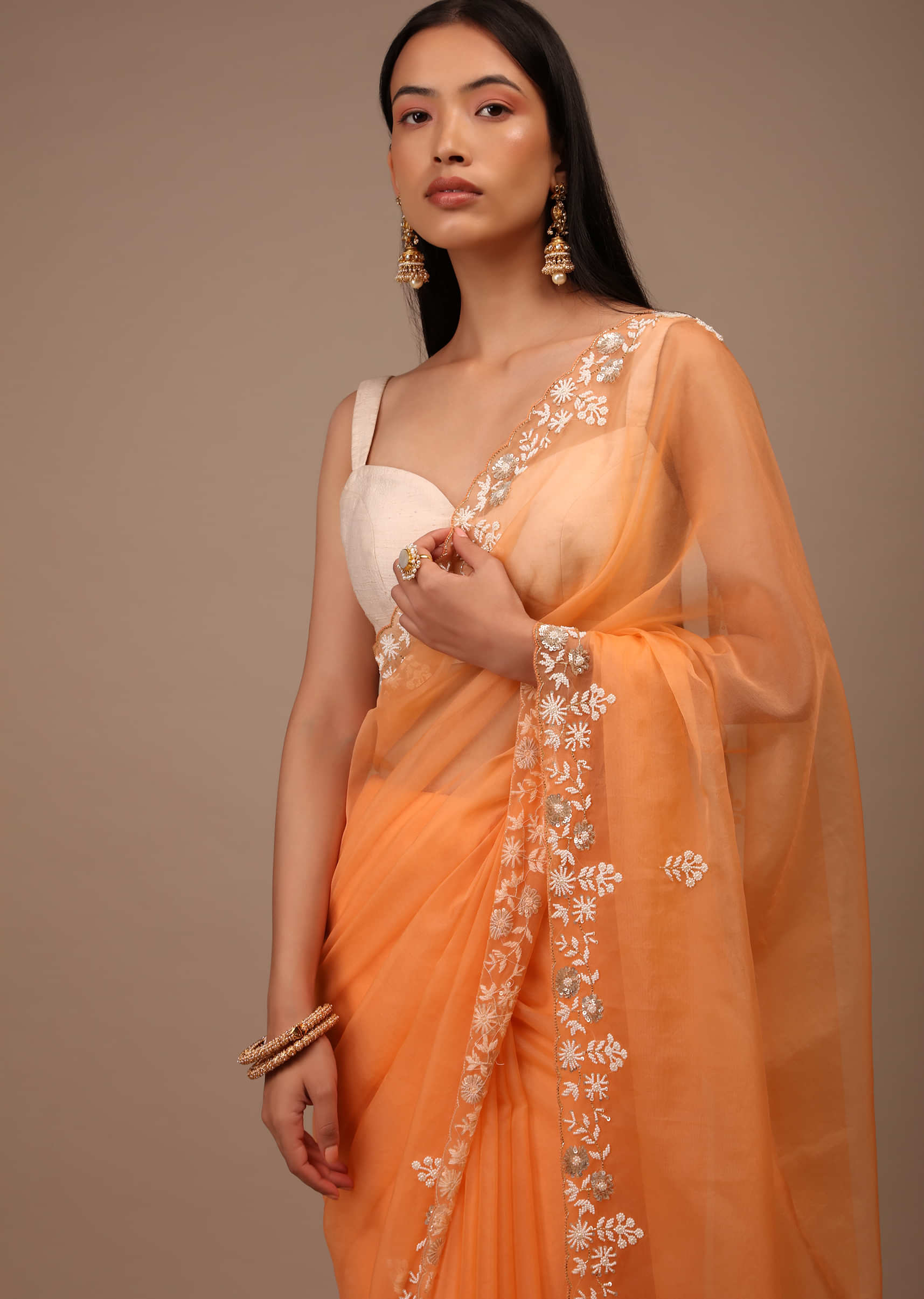 Melon Orange Saree In Organza With Hand Embroidered Moti And Sequin Work On The Border And Butti Design
