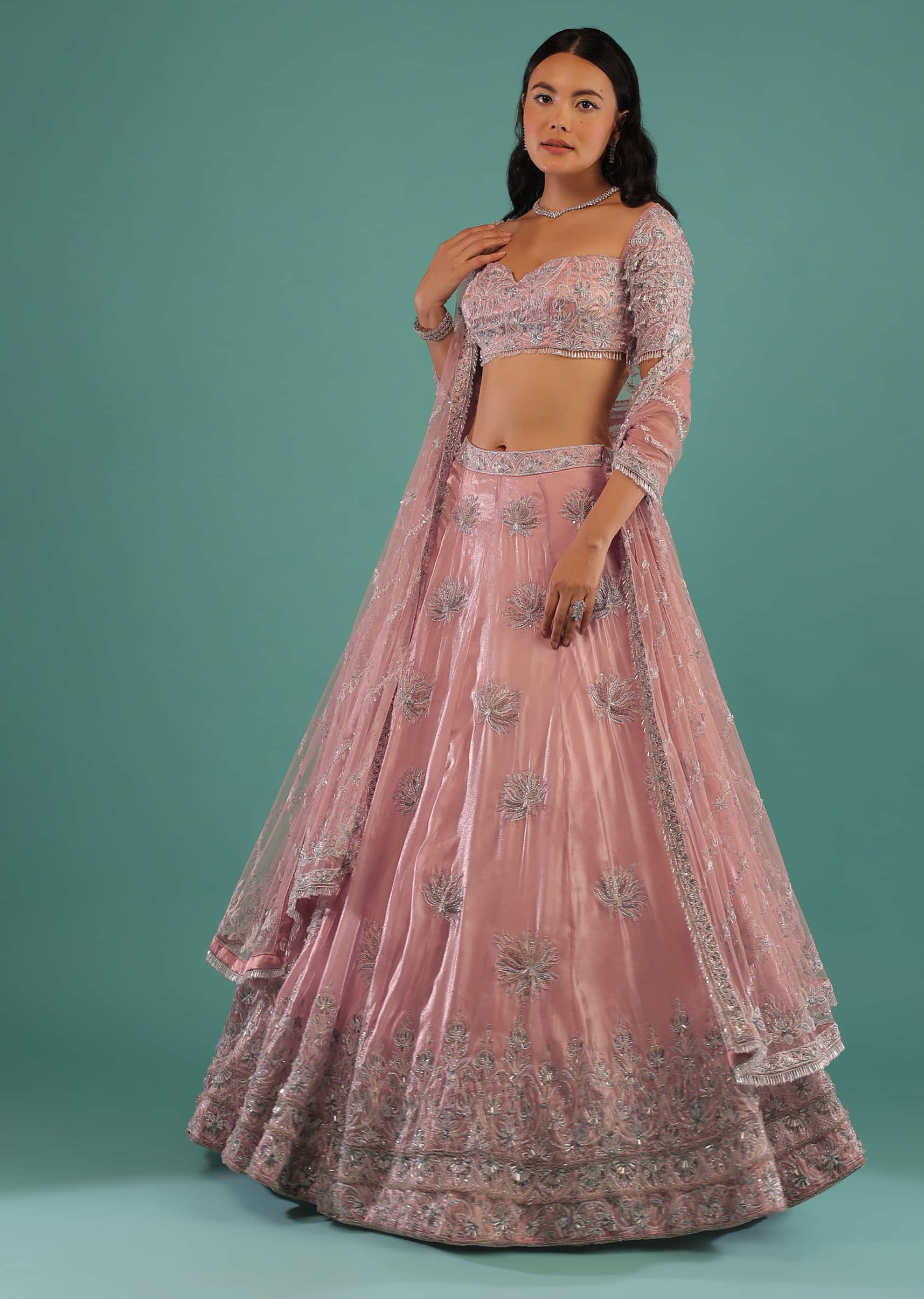 Powder Pink Lehenga And Off Shoulder Crop Top In 3D Floral Motifs Embroidery Paired With A Matching Net Dupatta
