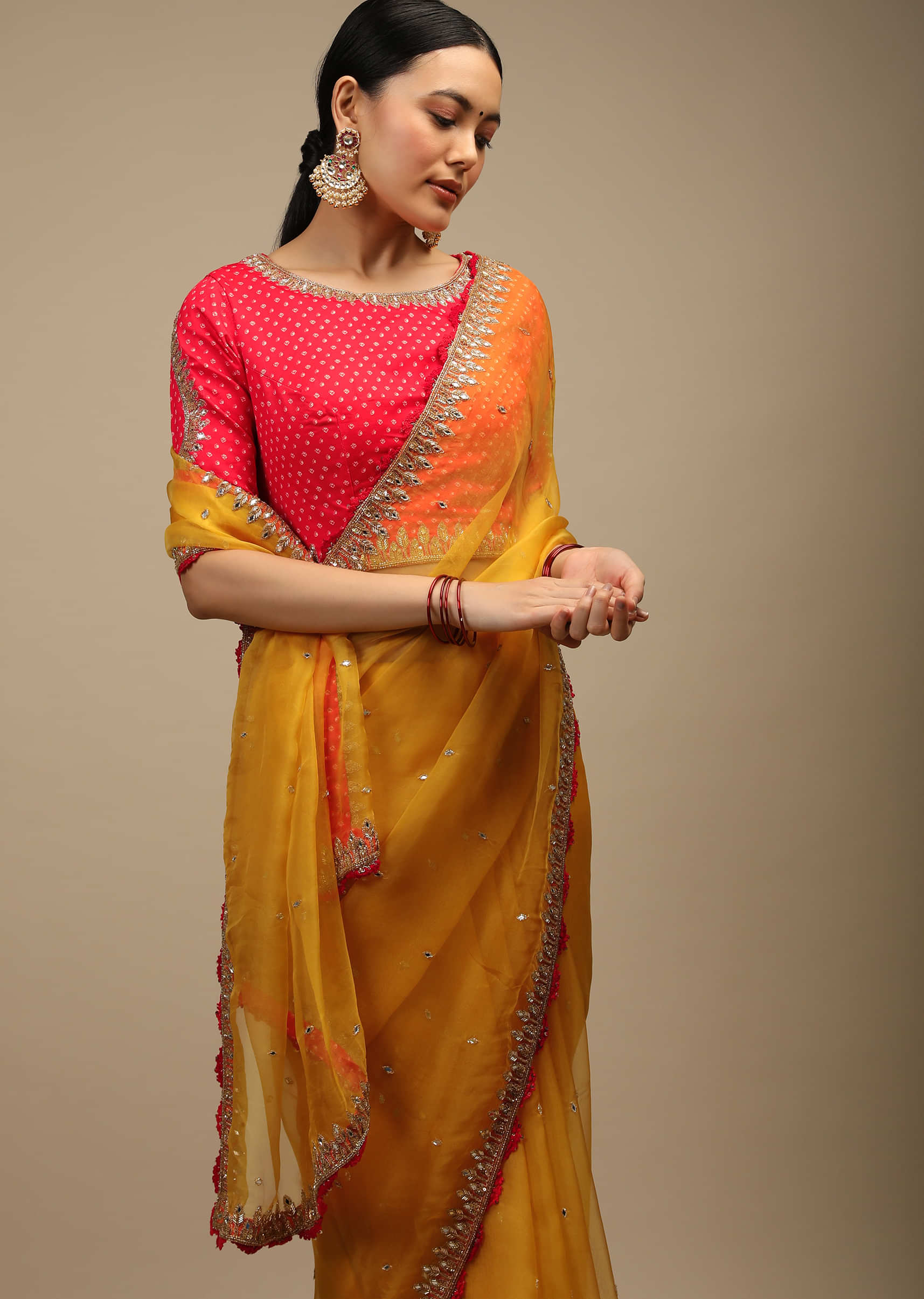 Amber Yellow Saree In Organza With Mirror Work And A Coral Choli Adorned In Bandhani Print  