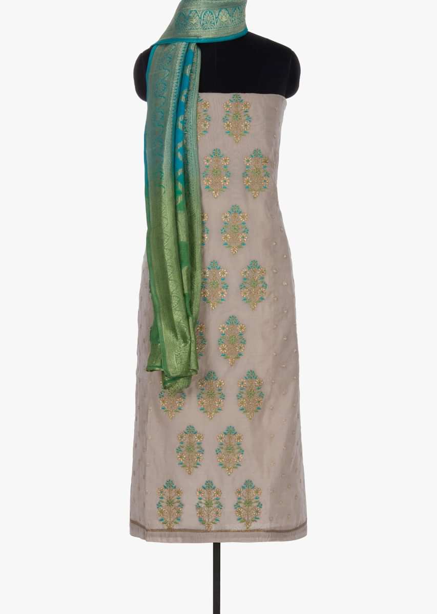 Beige unstitched suit paired with turq blue bottom and shaded brocade dupatta 