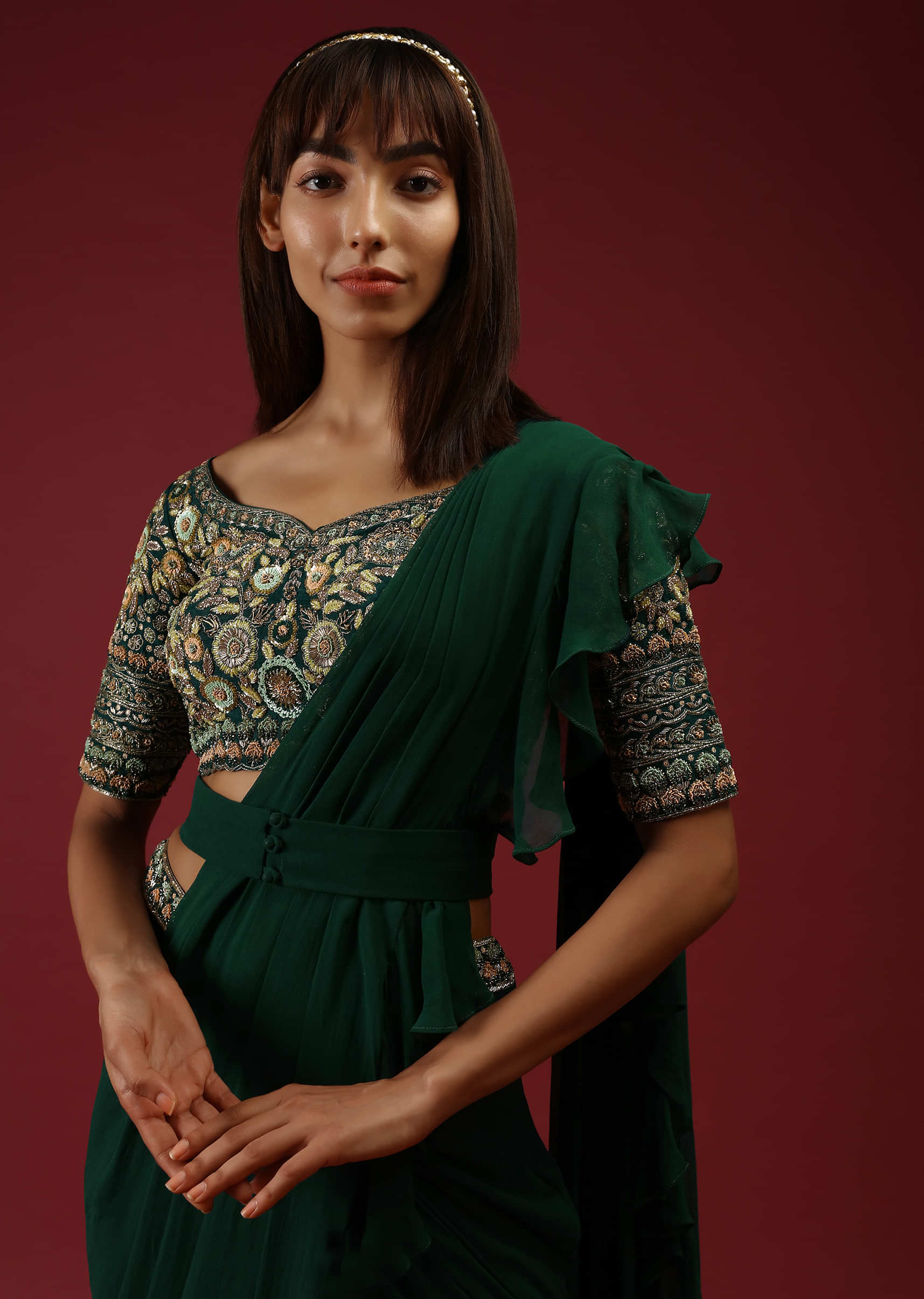 Bottle Green Ready Pleated Ruffle Saree With A Multi Colored Hand Embroidered Blouse And Plain Belt  