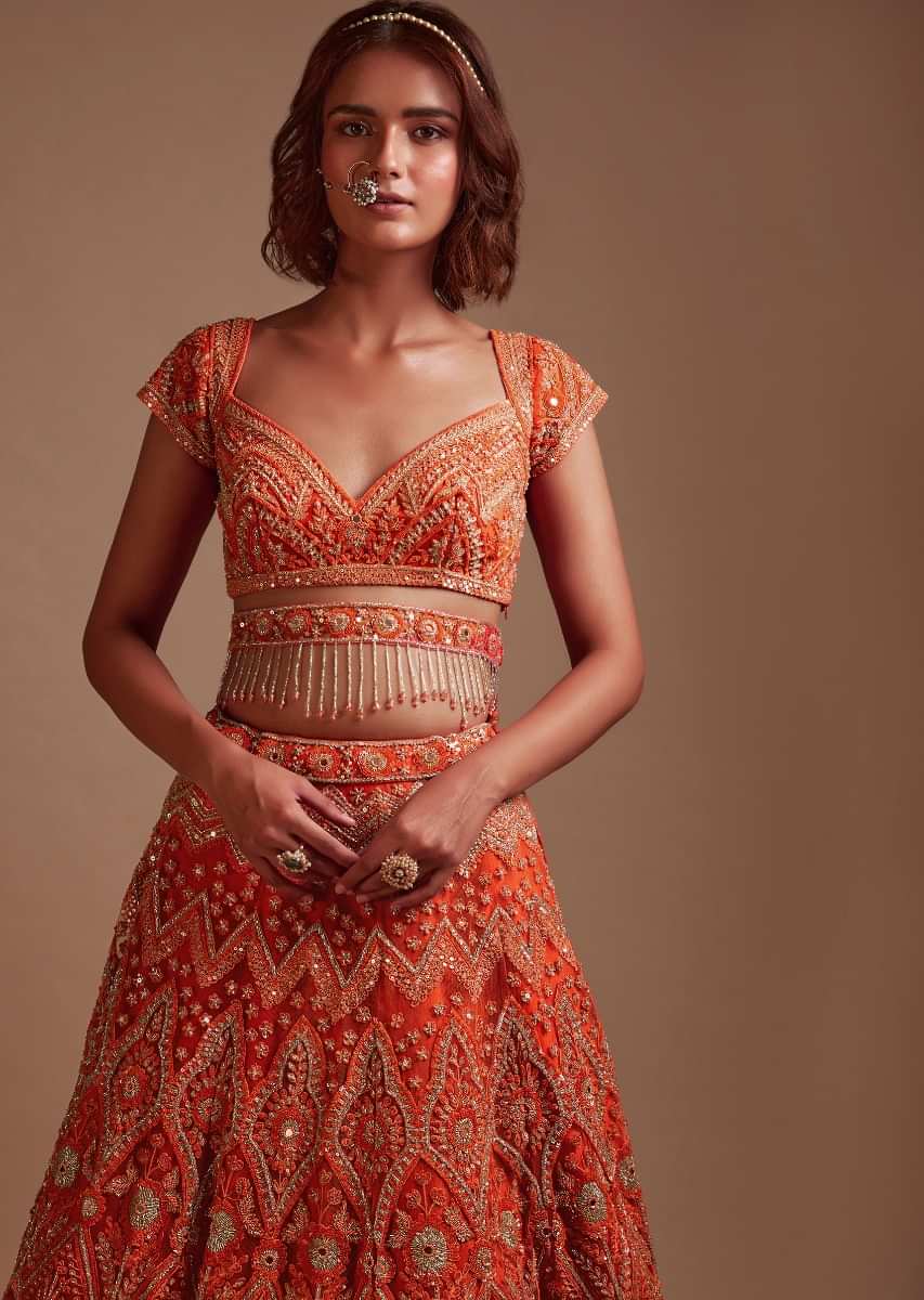 Coral Orange Lehenga Choli In Net With Mirror And Sequins Embroidered Floral And Mughal Embroidery Along With Belt Detailing 