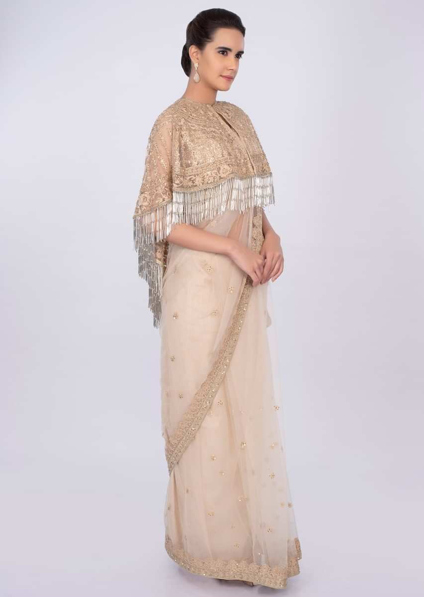 Cream net saree with embroidered  tasseled cape only on kalki