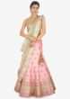 Baby pink raw silk lehenga set  paired with a contrasting green net dupatta