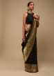Black Saree In Art Handloom Silk With Woven Multi Colored Peacock Motifs On The Border, Floral Buttis And Unstitched Blouse  