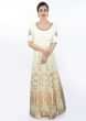 Cream cotton anarkali dress in weaved butti paired with matching lycra pant and turq green net dupatta
