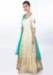 Cream cotton anarkali dress in weaved butti paired with matching lycra pant and turq green net dupatta