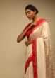 Cream Saree In Silk With Lurex Woven Chevron Design And Red Bandhani Border Along With Unstitched Blouse  