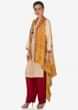 Cream suit with tassel matched with mustard bandhani jacket only on Kalki