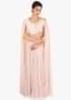 Light pink soft net gown in in side pleats and fancy cape