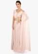 Light pink soft net gown in in side pleats and fancy cape