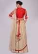 Oat tan brocade skirt with attached organza dupatta and red raw silk embroidered blouse