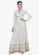 Off-white anarkali suit enhanced in Lucknowi Thread work with fancy stone and tassel design