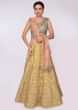 Olive green blouse paired with butter yellow heavy embroidered lehenga and coral peach net dupatta