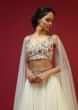 Powder White Lehenga Choli With Attached Cape And Hand Embroidery Using Colorful Resham And Sequins In Floral Motifs 