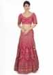 Rani pink raw silk heavily embellished lehenga paired with embroidered blouse and powder pink net dupatta