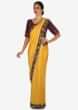 Yellow saree in satin silk with a navy blue blouse embroidered with zardosi and thread work only on Kalki