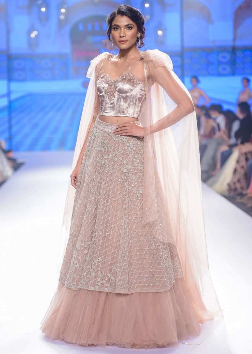 Dusty pink multi layered net skirt with paris velvet bustier having trail attached at the shoulder with tassel 