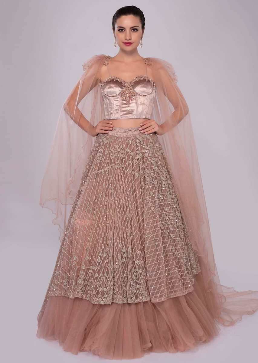 Dusty pink multi layered net skirt with paris velvet bustier having trail attached at the shoulder with tassel 
