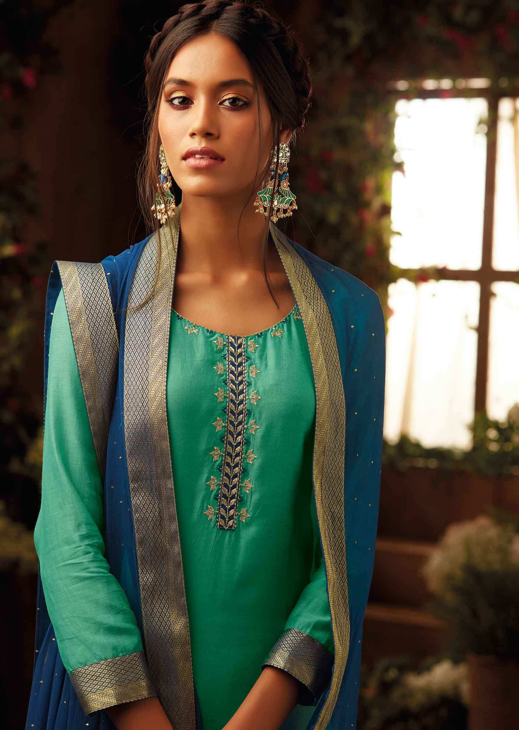 Fern green unstitched suit paired with  floral weaved bottoms and chiffon dupatta with brocade border
