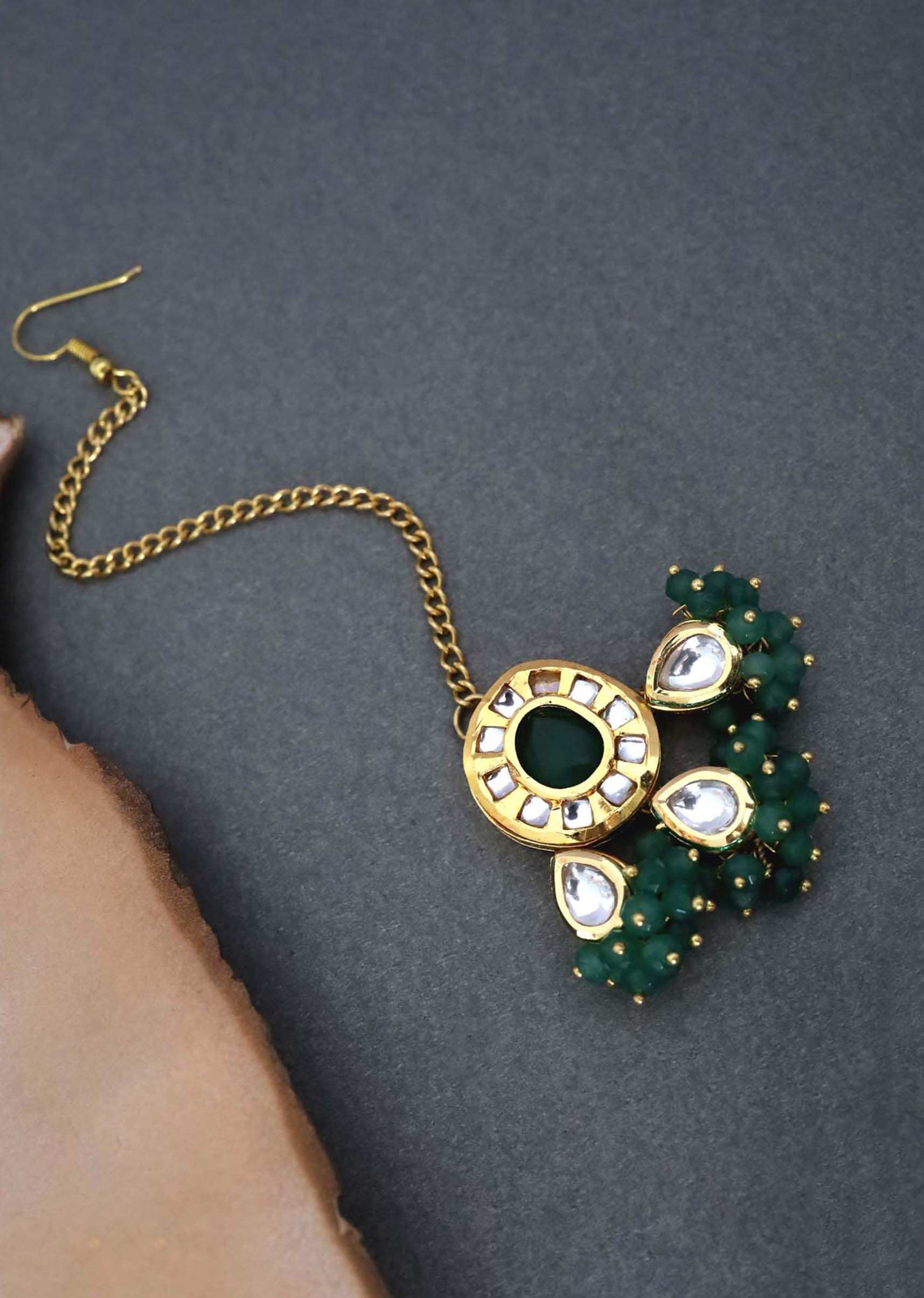 Gold Plated Mangtika With Kundan And Green Stone Centre With Dangling Smaller Stones