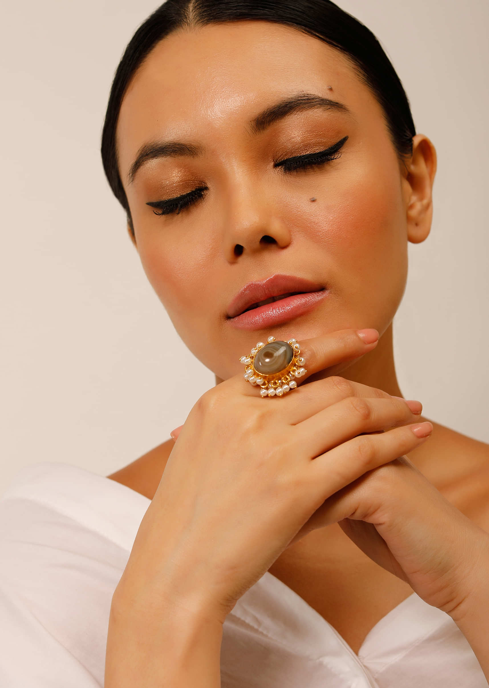 Gold Plated Ring With An Oval Shaped Grey Semi Precious Stone And Moti Tassels 