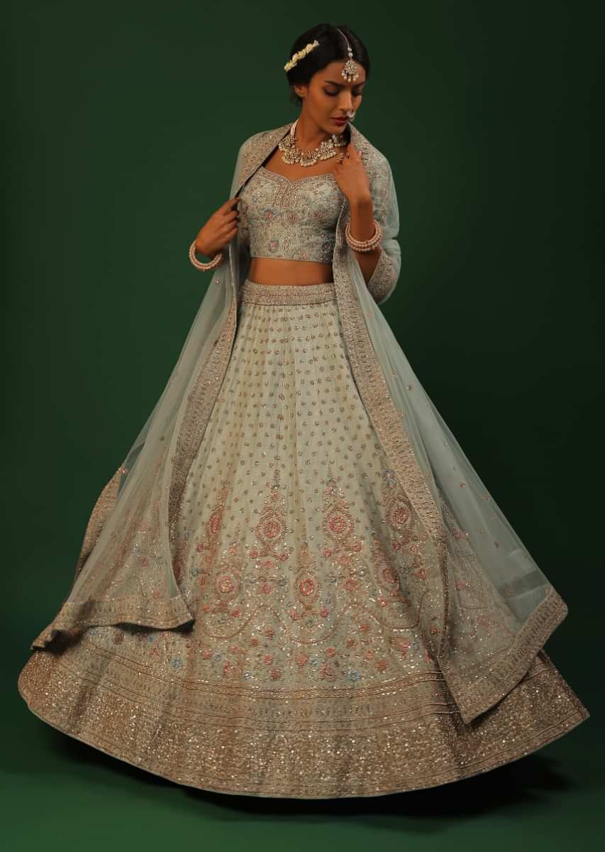 Greyish Green Lehenga Choli In Raw Silk With Multi Colored Resham Flowers And Gold Zardosi Embroidered Mughal Border And Buttis 