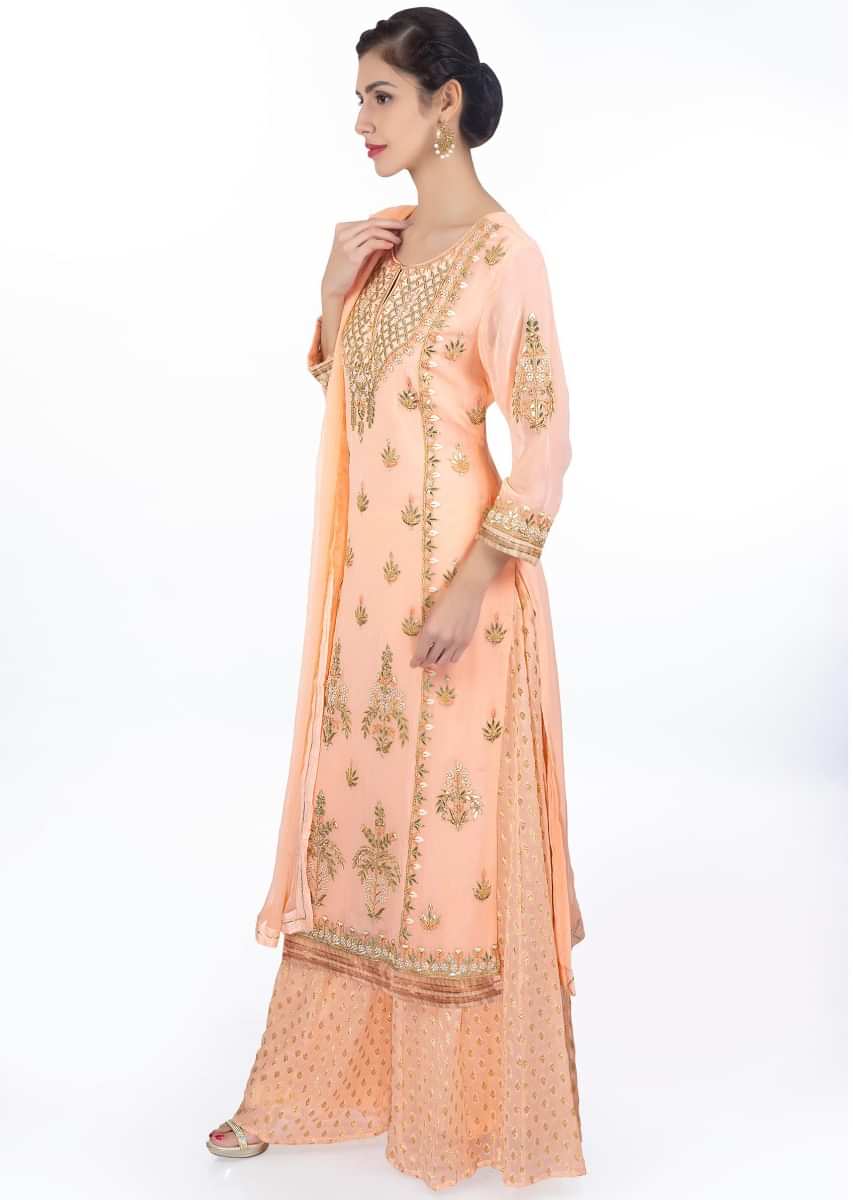 Light peach embroidered georgette suit paired with weaved palazzo and matching chiffon dupatta