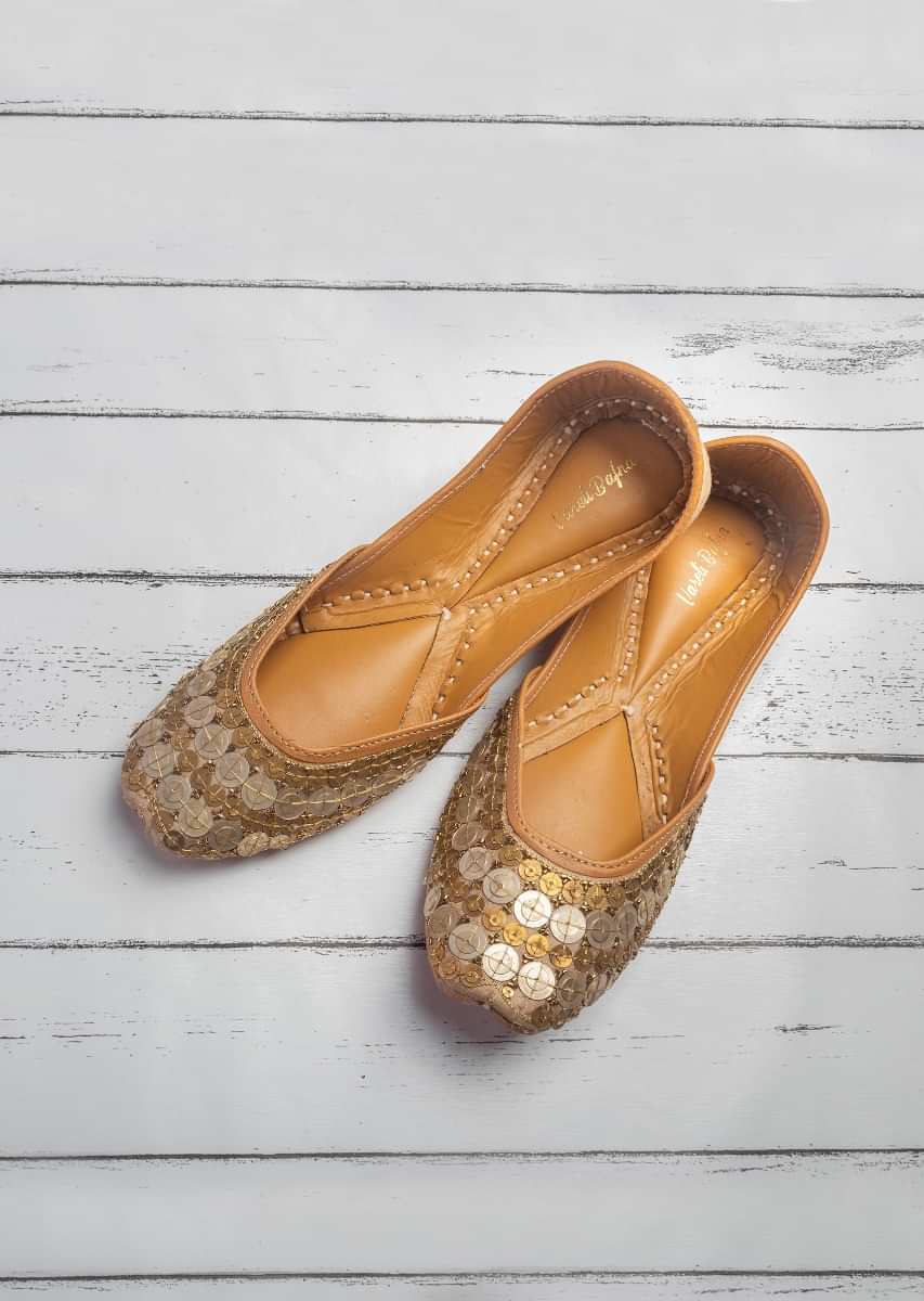 Gold Juttis In Raw Silk With Coin And Zari Work In Gold And Silver By Vareli Bafna