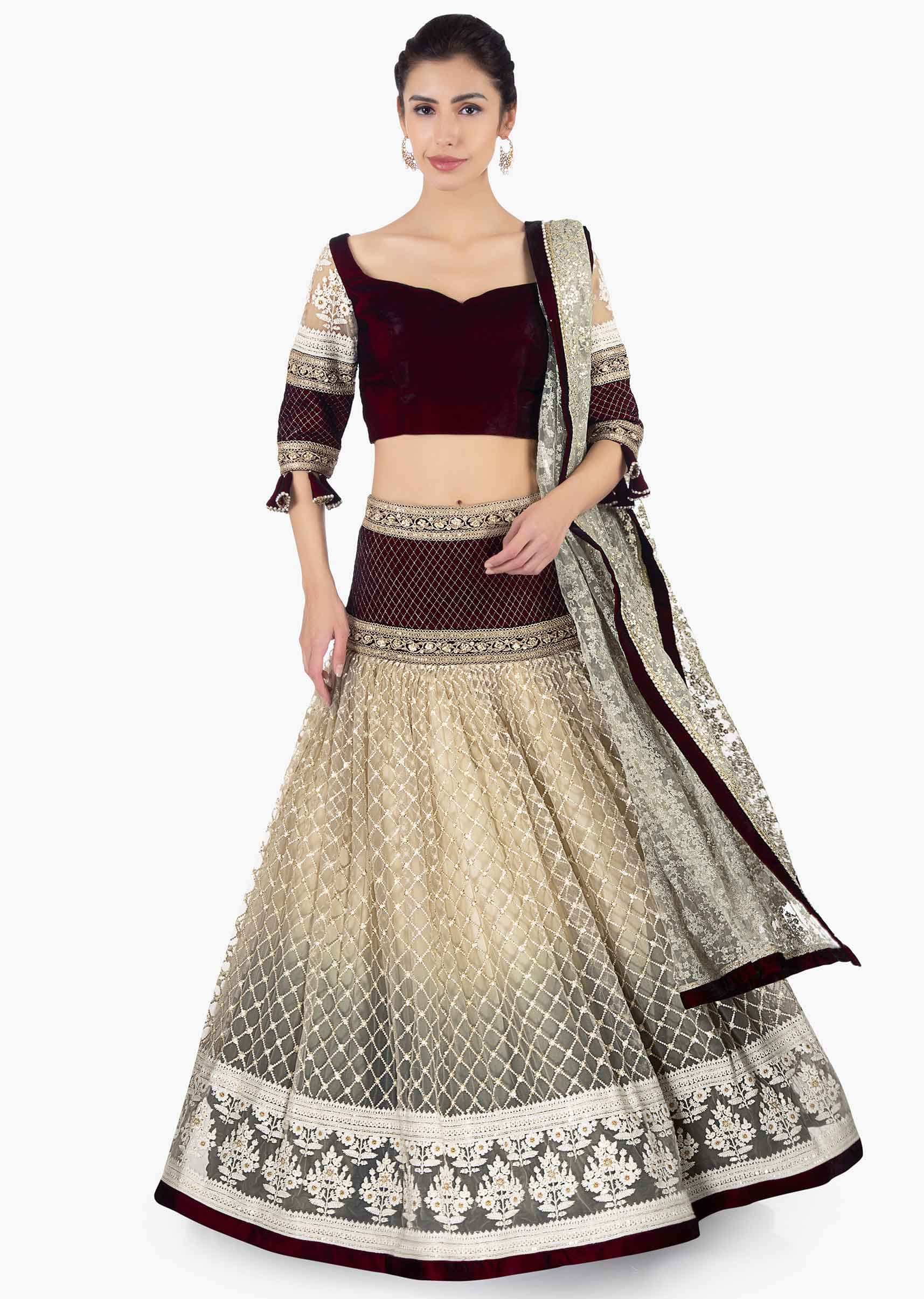 Maroon velvet blouse paired with lehenga in sequins and jaal work and a matching net dupatta 