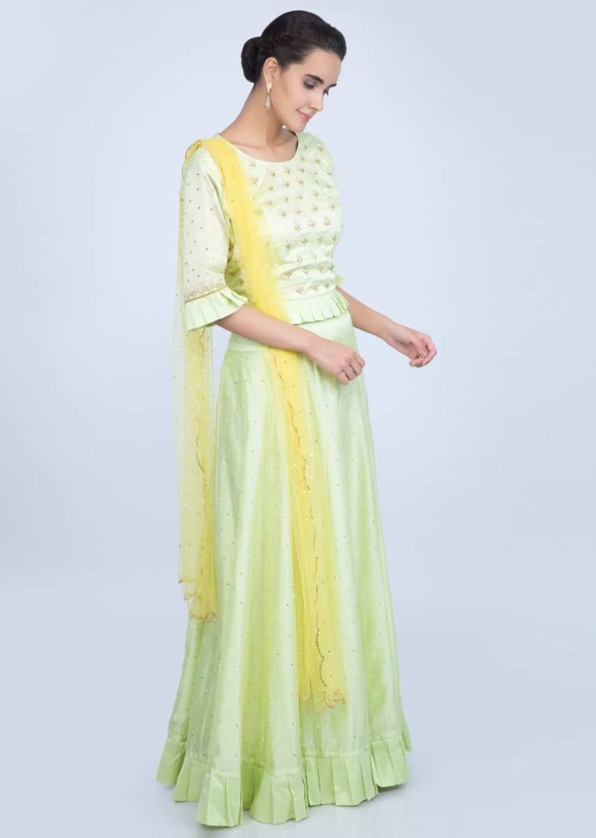 Mint green cotton silk lehenga and blouse paired with a contrasting yellow net dupatta only on Kalki
