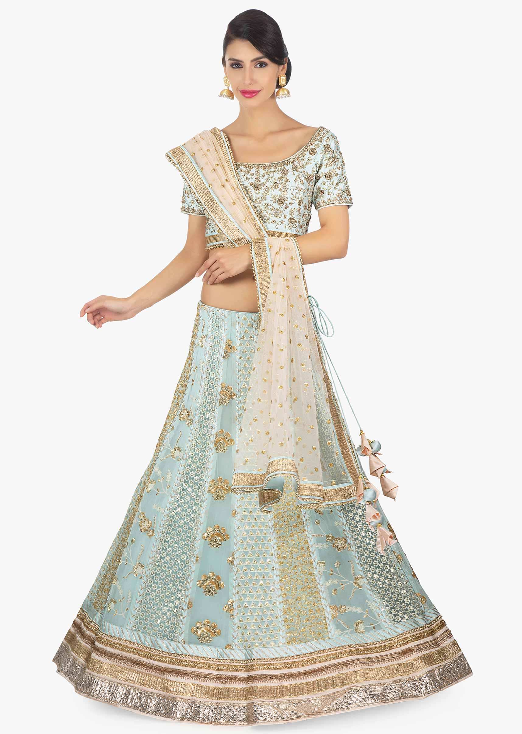 Mint green raw silk blouse paired with georgette lehenga in alternate kali along with a cream net dupatta