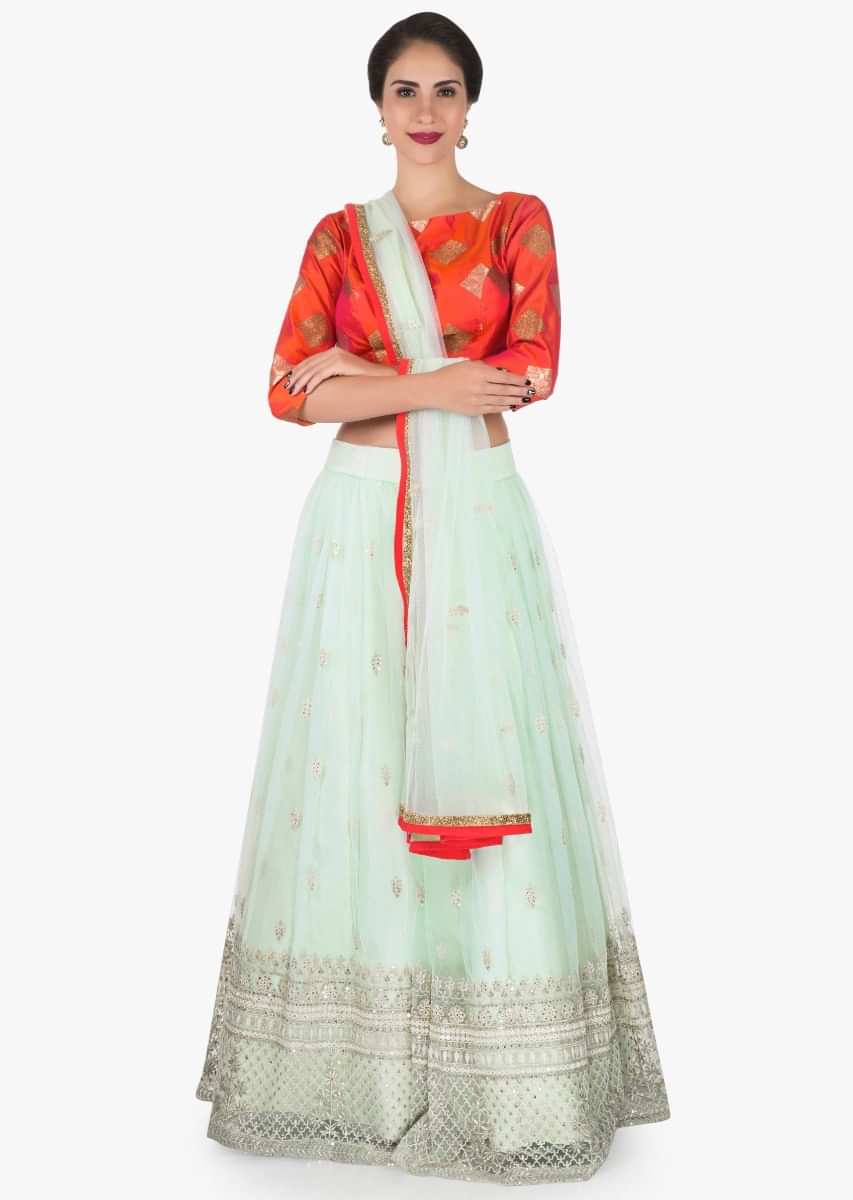 Mint blue lehenga with a orange brocade silk blouse embellished in thread work only on Kalki
