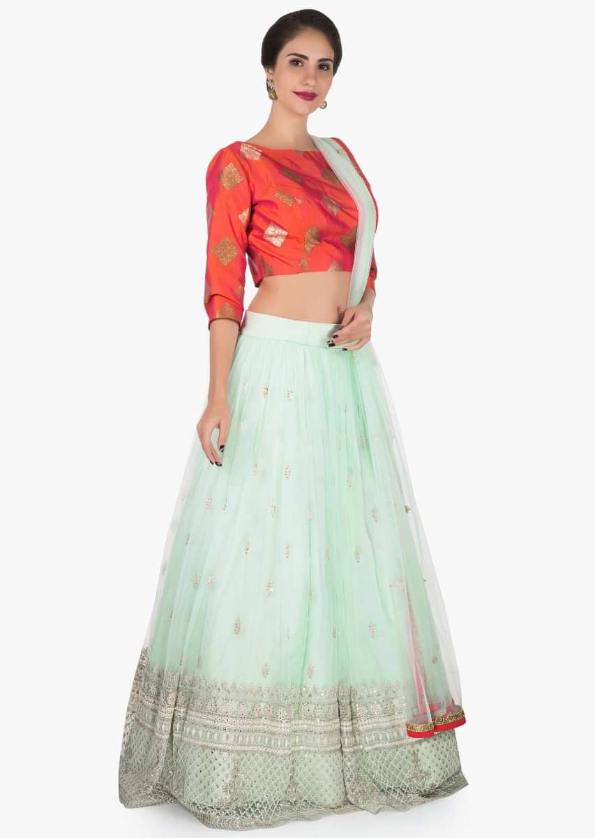 Mint blue lehenga with a orange brocade silk blouse embellished in thread work only on Kalki