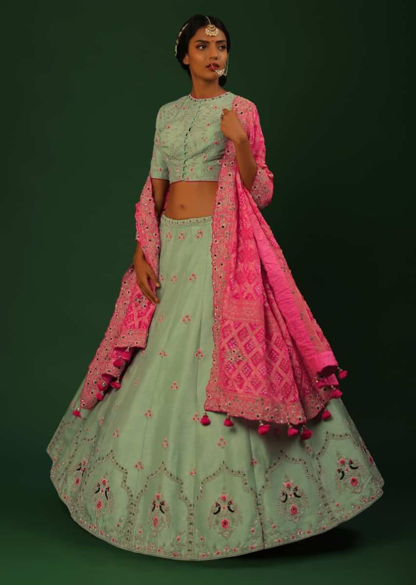 Mist Green Lehenga Choli With Colorful Resham And Zardosi Work In Peacock Motifs On The Border, Floral Buttis And Magenta Bandhani Dupatta 