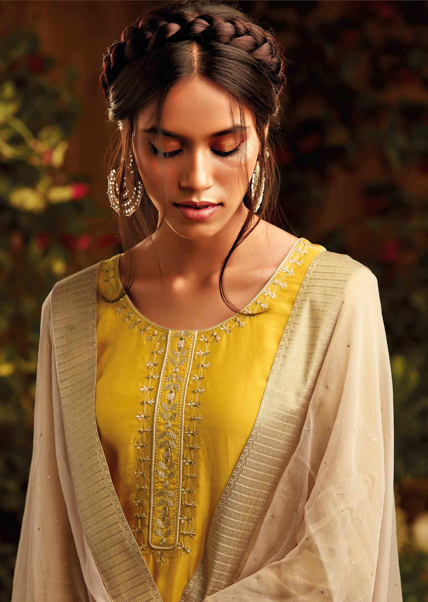 Mustard cotton silk unstitched suit paired with floral weaved bottoms and chiffon dupatta with brocade border