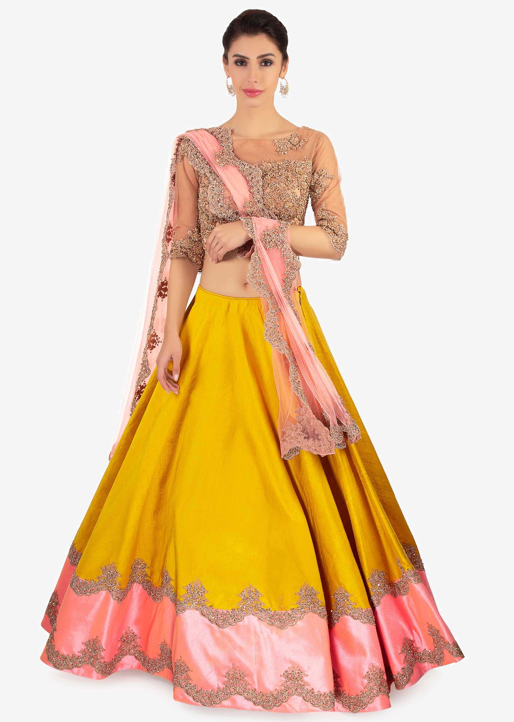 Mustard raw silk lehenga paired with a beige net blouse and pink net dupatta