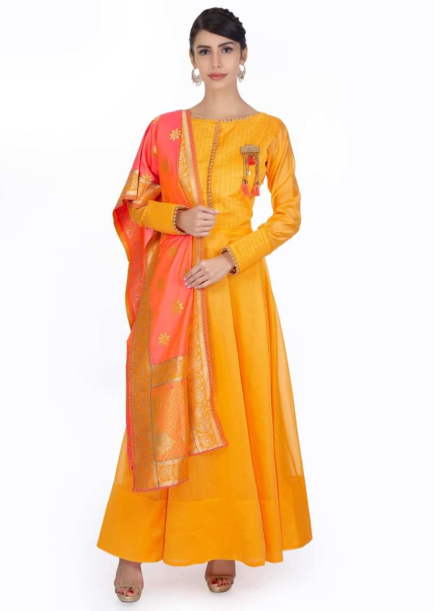 Mustard silk anarkali dress paired with  coral silk weaved dupatta with brocade border 