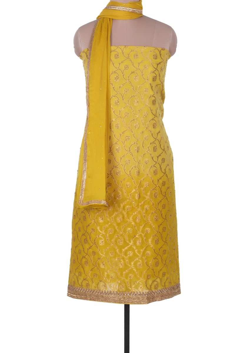 Mustard yellow unstitched brocade silk suit adorn with kundan work 