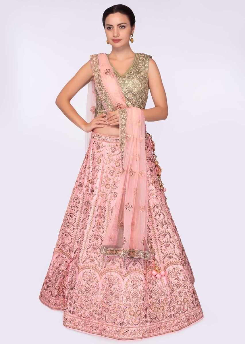 Olive green blouse paired with pink heavy embroidered lehenga and net dupatta