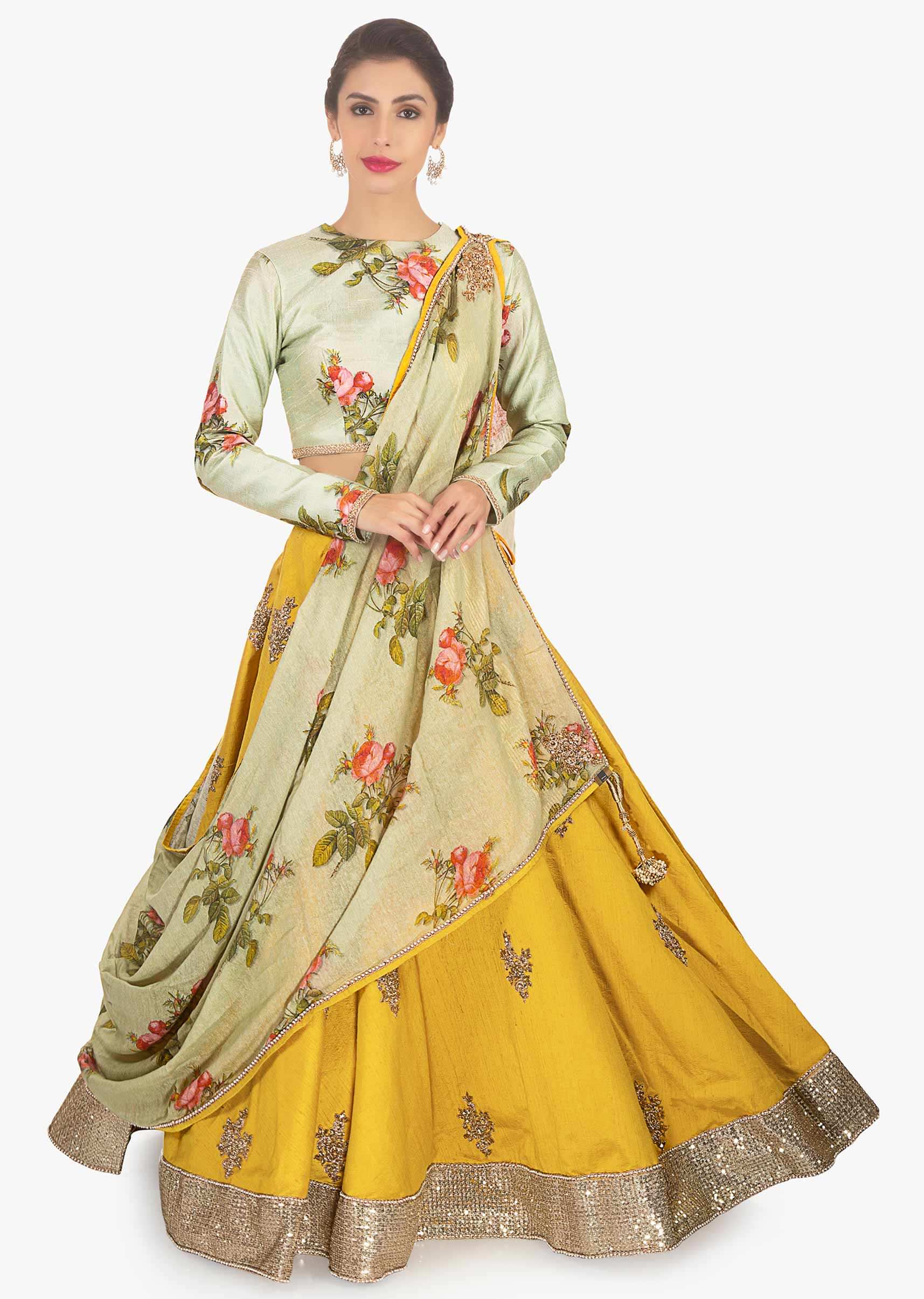 Oyster green raw silk blouse paired with mustard lehenga and floral printed dupatta 