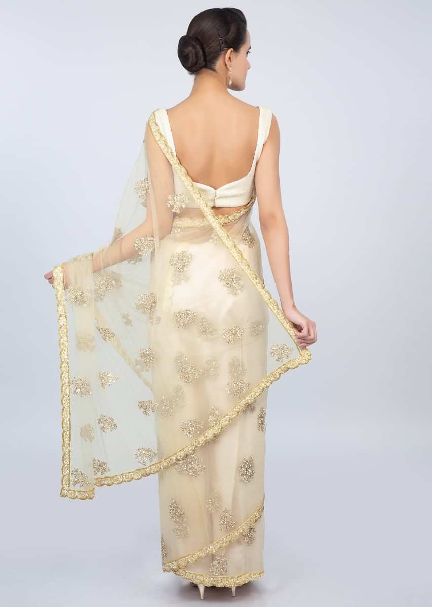 Pale cream sheer net saree with butti and embroidered scallop border only on kalki