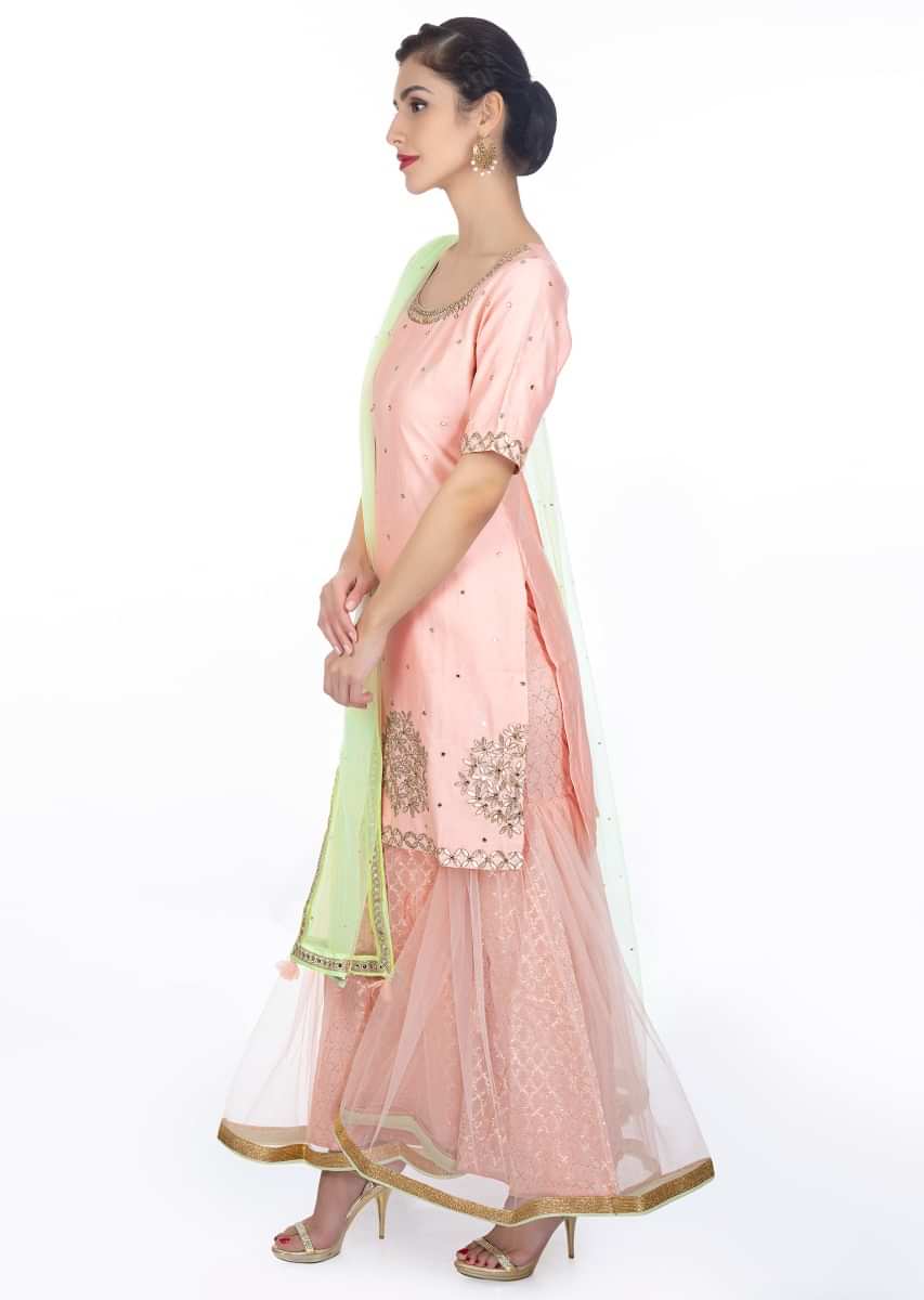 Peach embroidered silk suit paired with brocade lehenga in net lining and a contrasting  net dupattaonly 