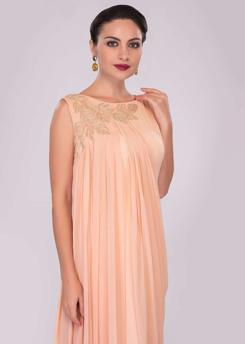 Peach georgette tunic dress enhanced with pleats and side cowl drape 