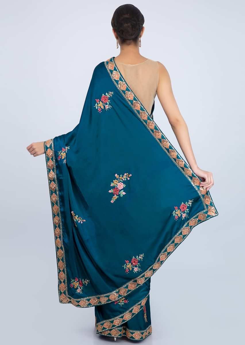 Peacock blue satin saree with multi color resham embroidered butti in floral motif only on Kalki
